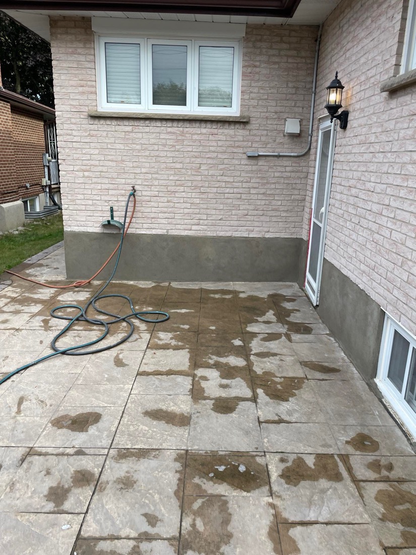 Backyard patio next to a freshly parged exterior foundation wall of a GTA home