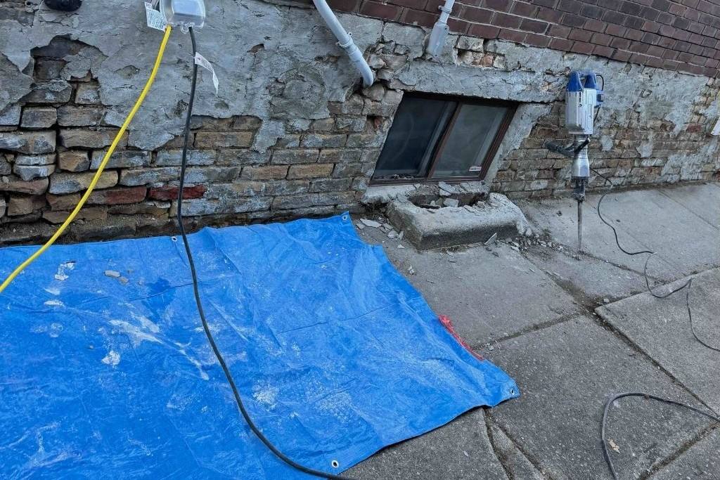 Cracked, exposed house foundation before parging in Toronto
