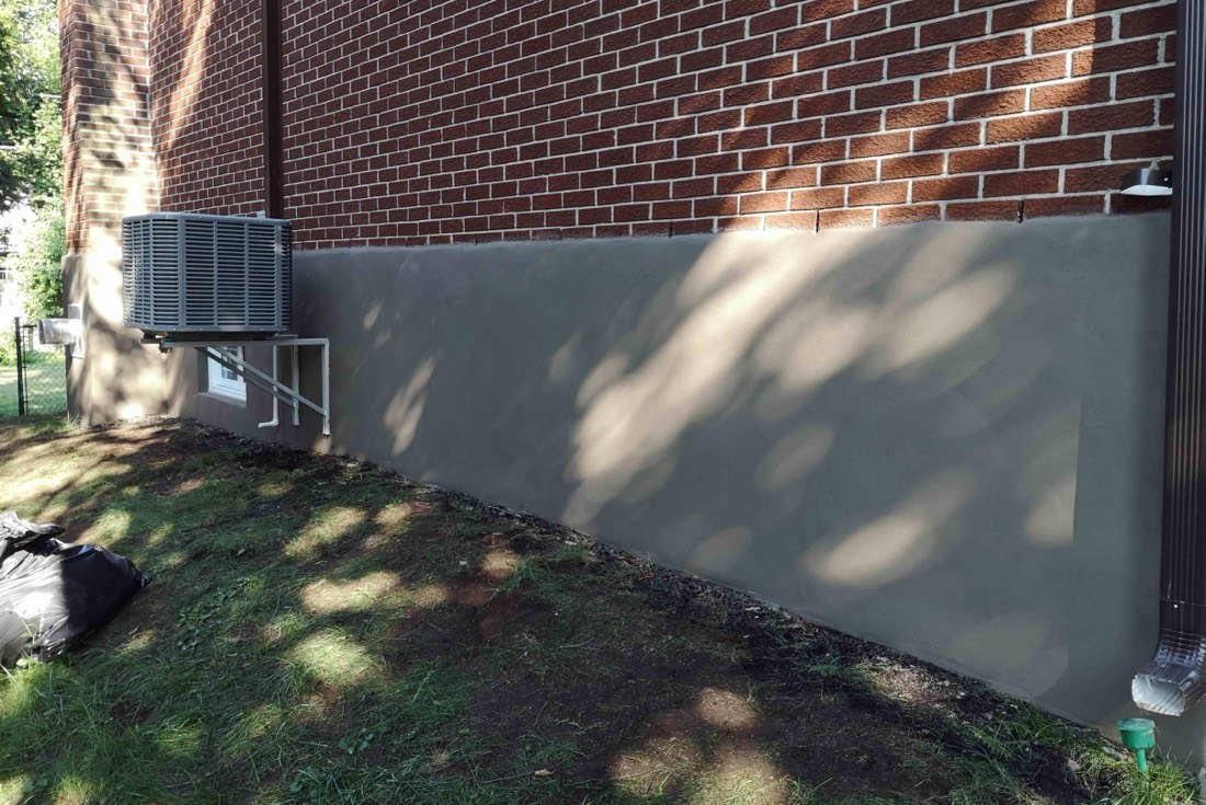 New parge coat along the brick foundation of a home in Hamilton