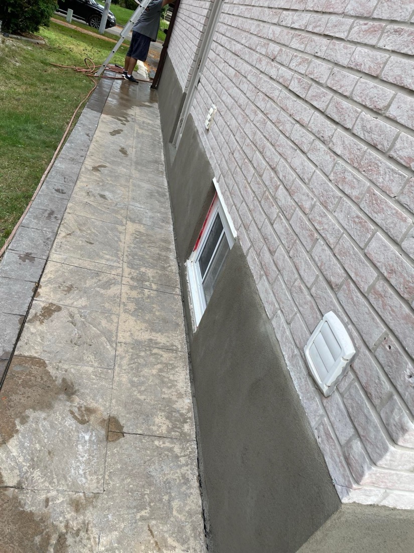 Side yard walkway running alongside a newly parged foundation wall at a GTA home